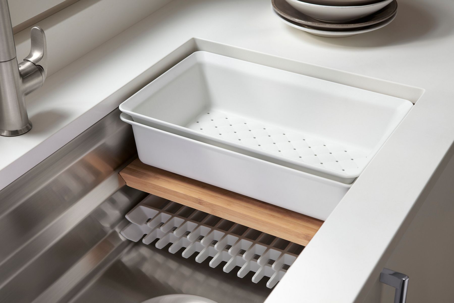 A workstation sink with three rows of accessories sitting on the sink's internal ledges.