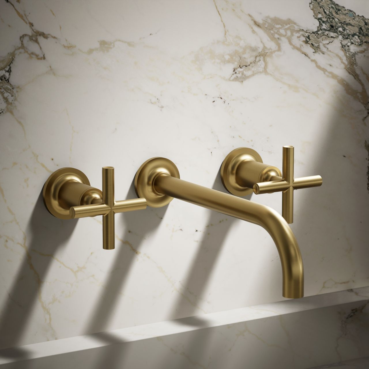 Wall-mount brushed gold bathroom faucet with cross handles and marble backsplash