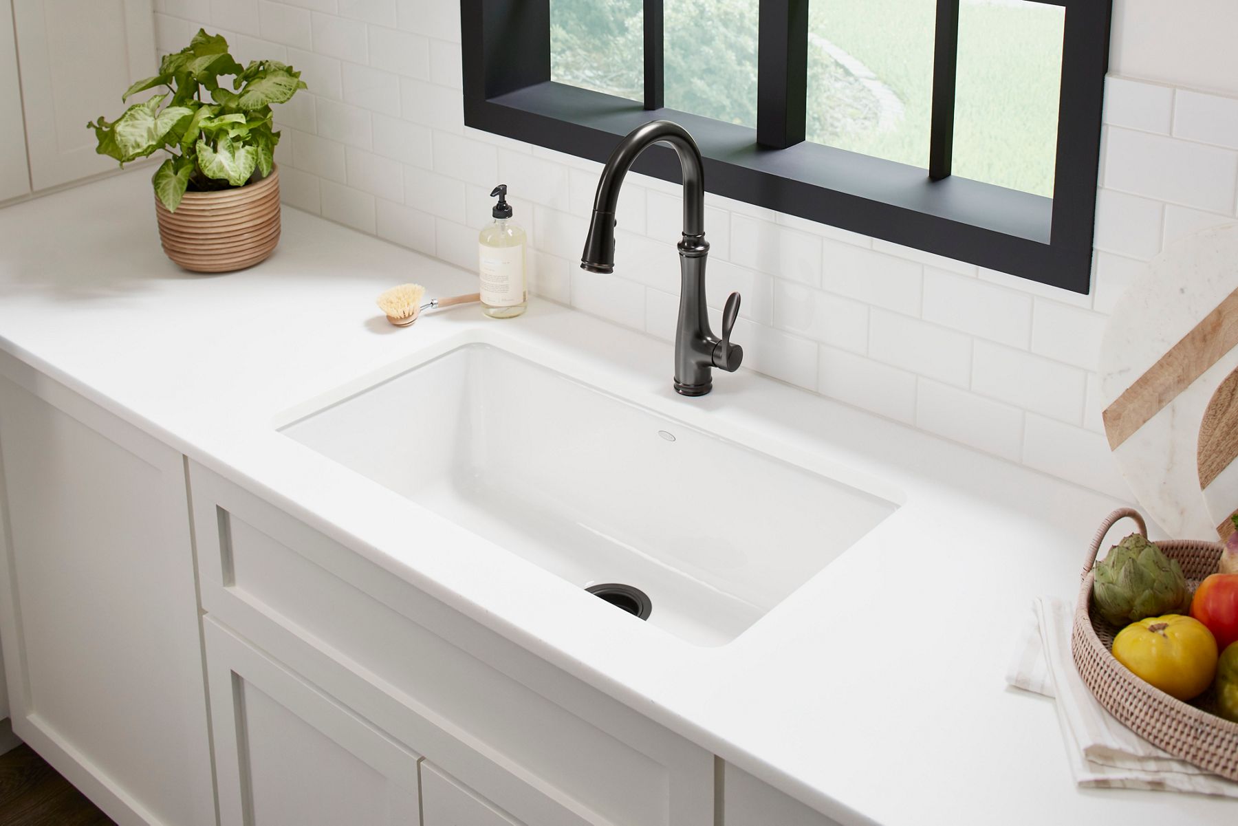 Oil-rubbed bronze pull-down kitchen faucet with white quartz countertop and window view