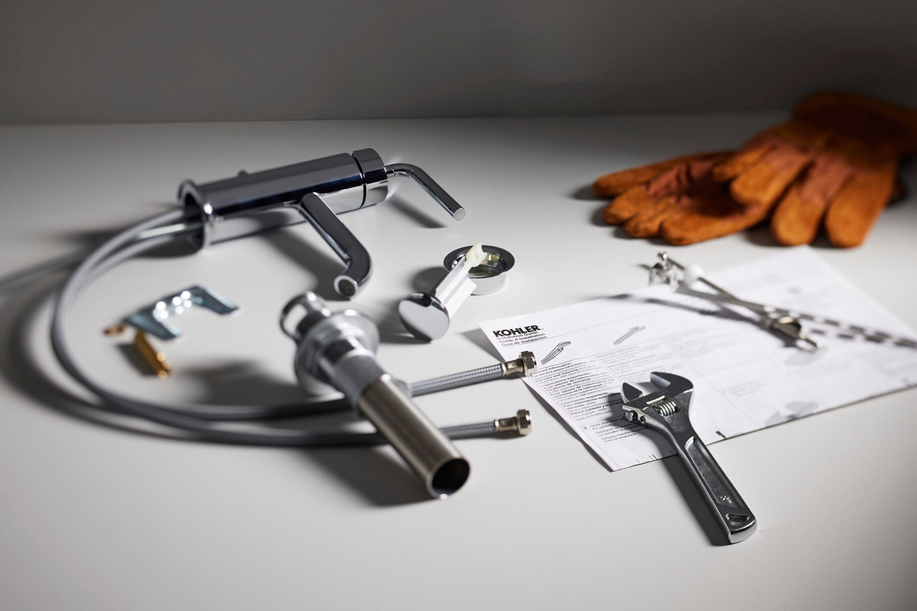 Plumbing tools and faucet parts laid out for installation.
