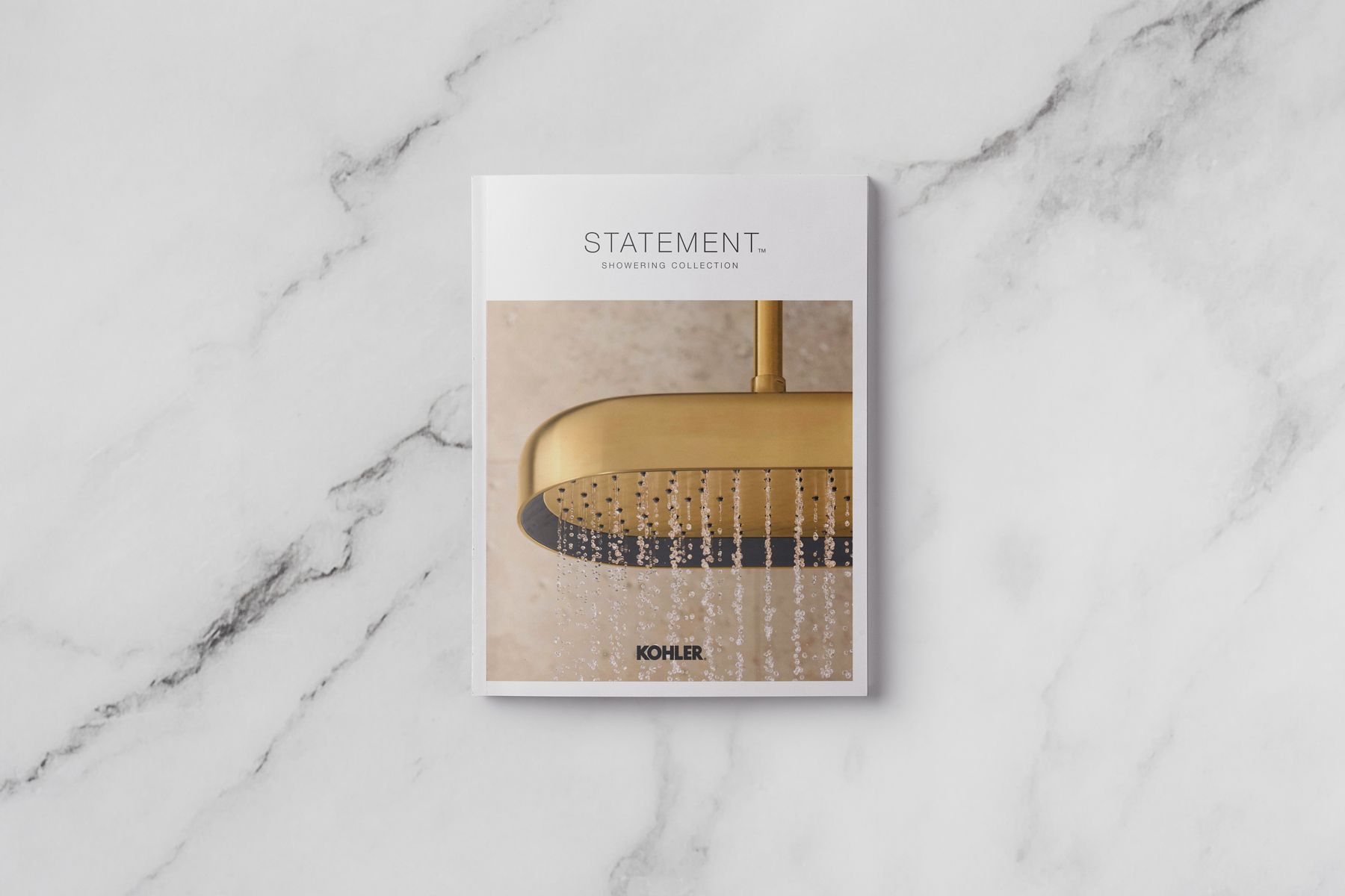 KOHLER Statement shower system catalog cover with gold showerhead.