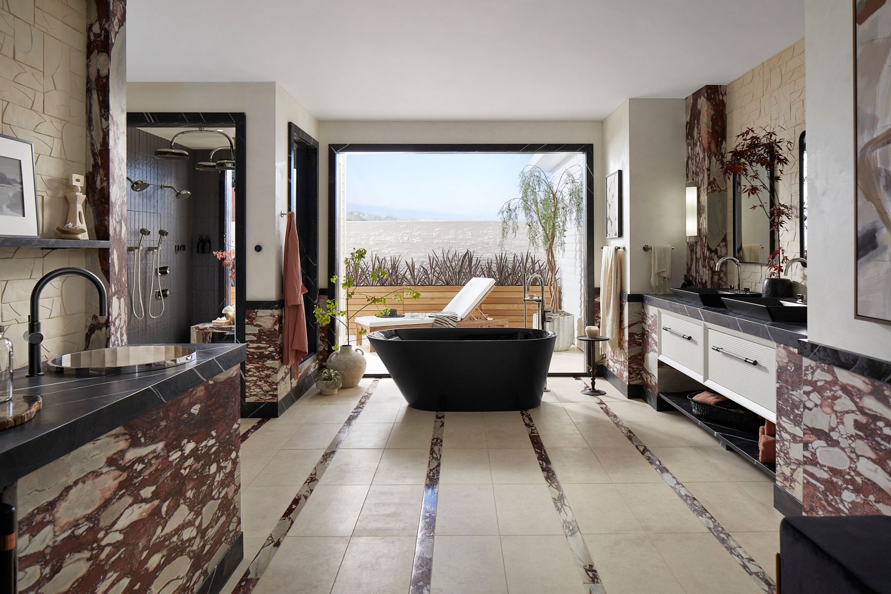 A large bathroom with a shower on the left, freestanding bath in the center and a double vanity on the right, with the room opening out through an open double door way onto an outdoor patio.