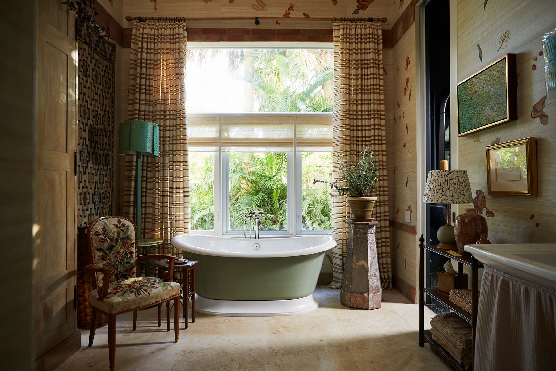 A bathroom in the decorative arts style with heavy use of patterns and texture, with a green and white freestanding bath in the center of the room.