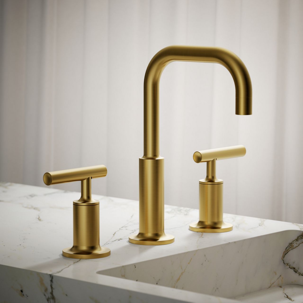 Modern brushed gold widespread faucet with T-shaped handles on marble countertop