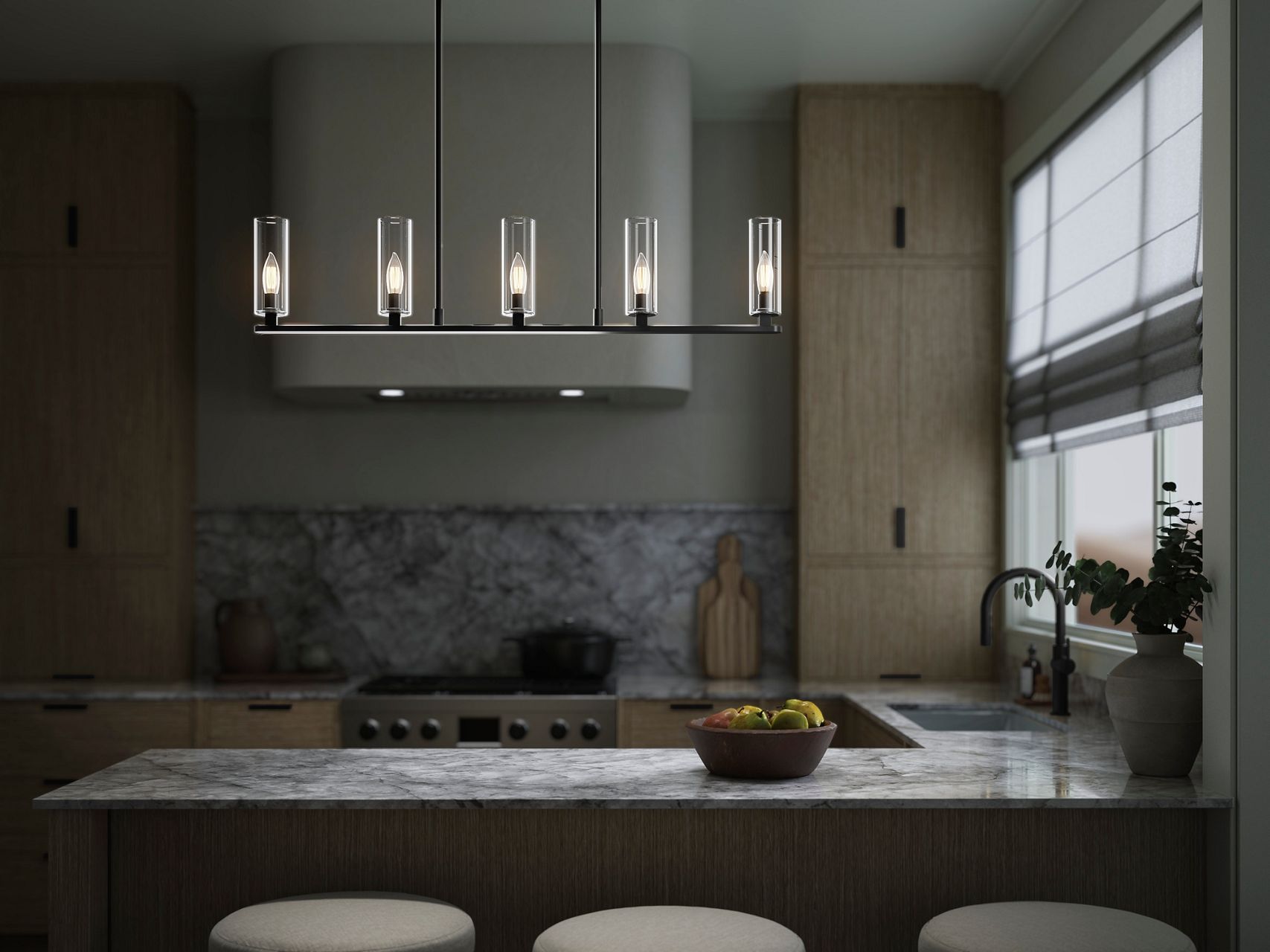 Minimalist kitchen with marble counters, light wood cabinetry, and modern linear pendant lighting.