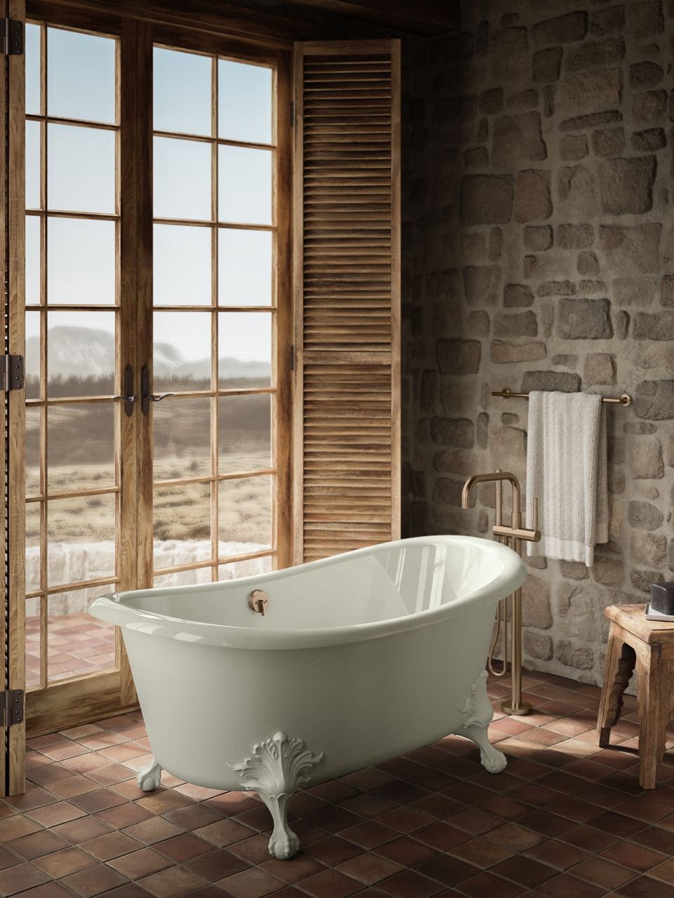 Rustic bathroom design featuring a freestanding clawfoot tub by large windows with wooden shutters.