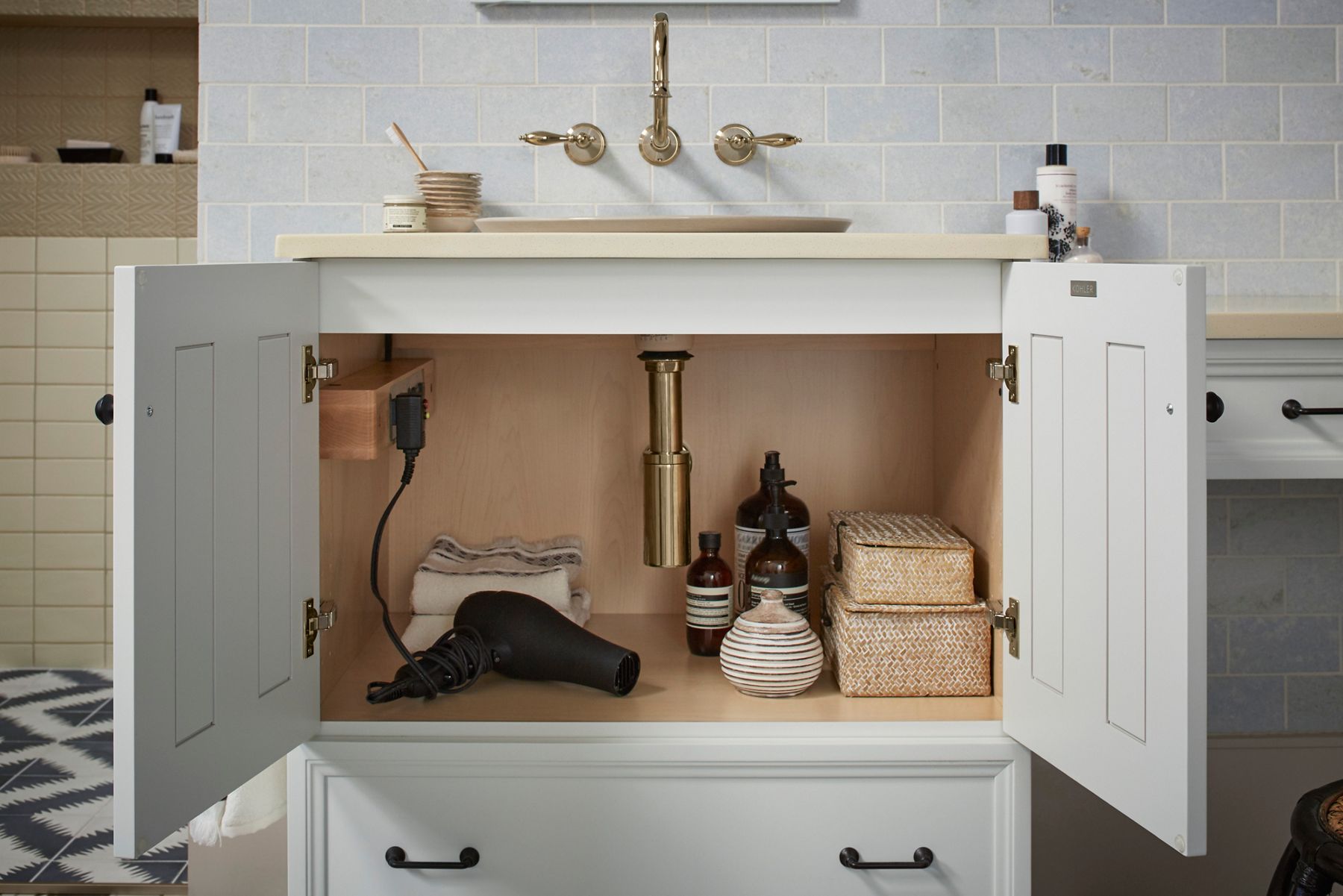 White vanity with open cabinet showing organized storage under sink.