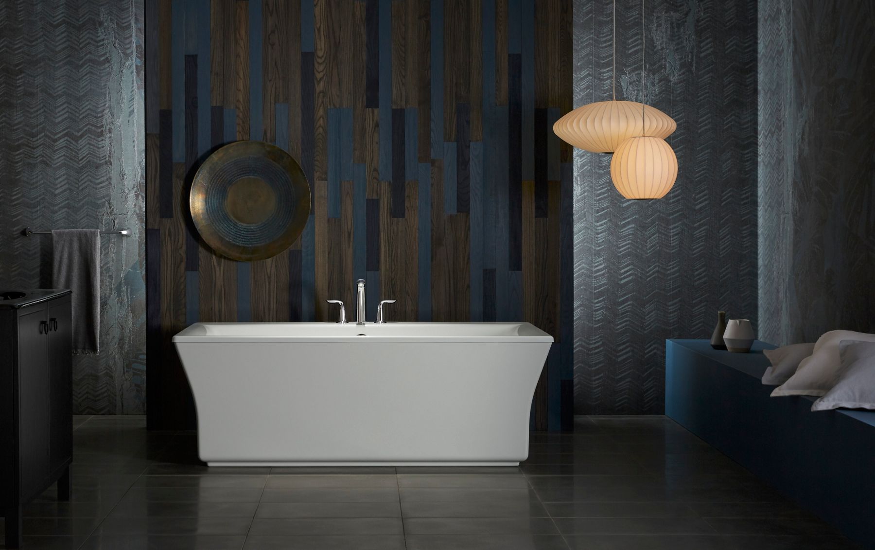 A Stargaze freestanding bath in a room with dark walls.