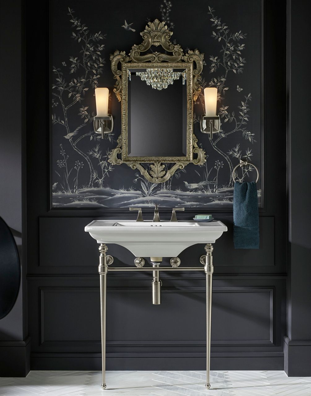 Ornate vanity with gold mirror and sconces in luxury bathroom