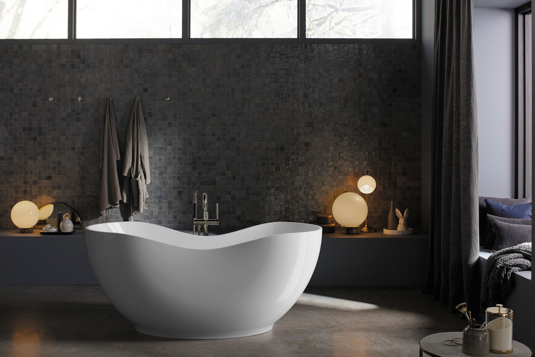An Abrazo freestanding bath in a room with dark walls.