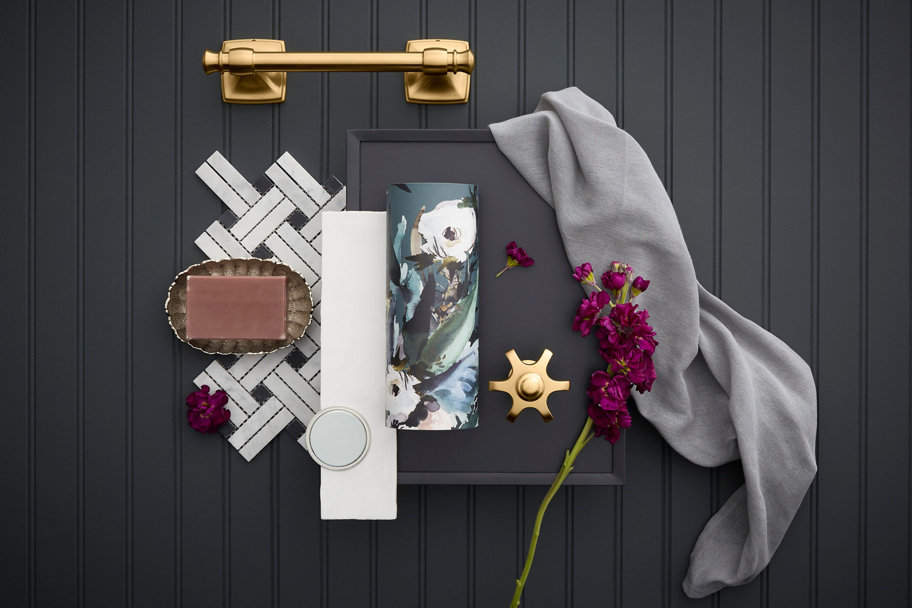 Decor mood board featuring brass drawer pull, tile sample, fabric swatch, and flowers.