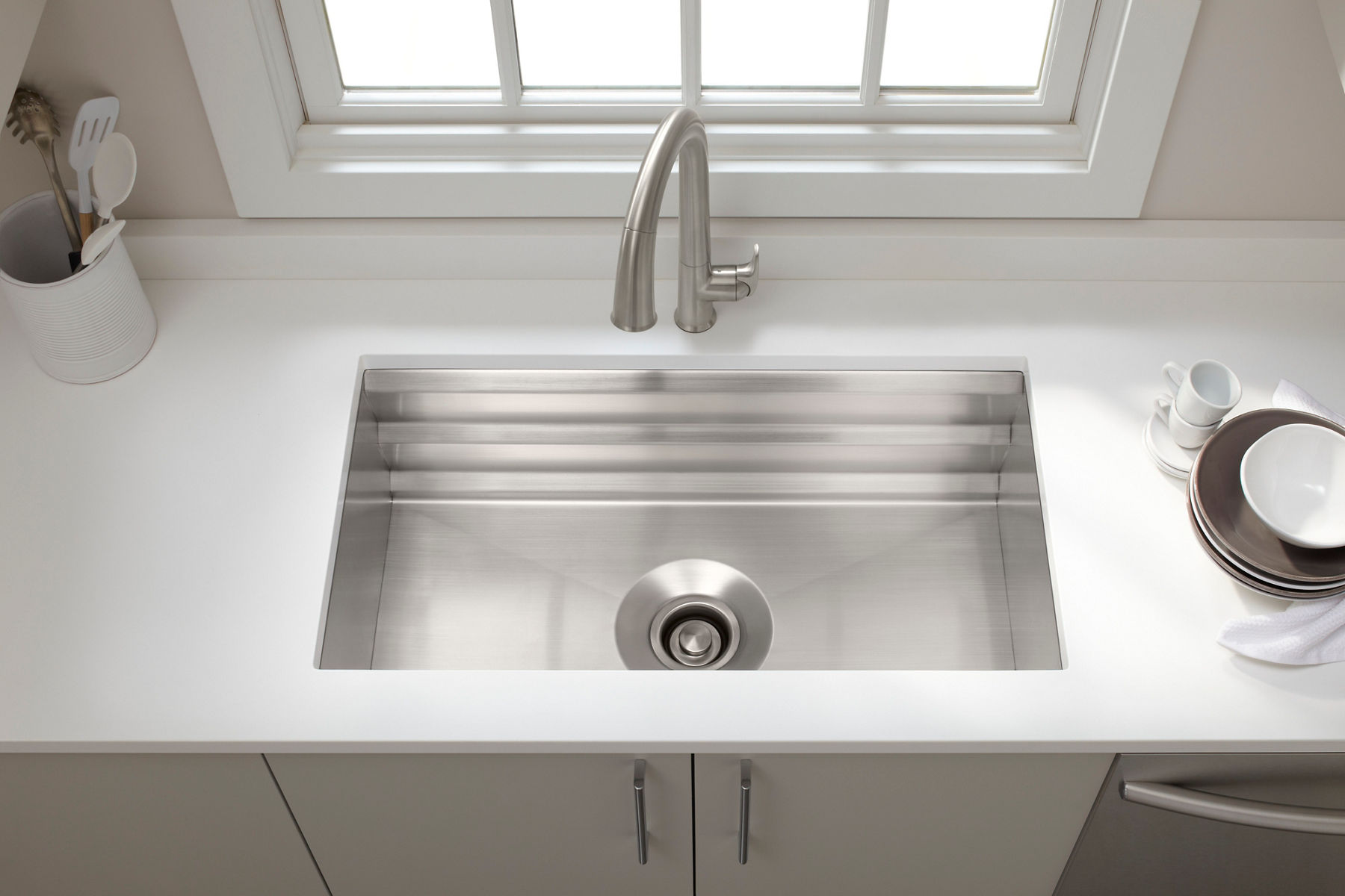 Stainless steel kitchen sink with a brushed finish and integrated drain, made from 80% recycled stainless steel materials.