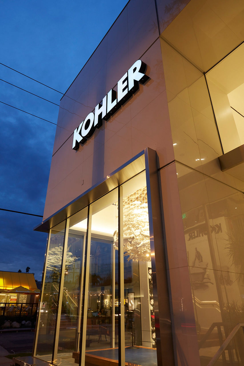 Exterior view of a KOHLER store in the evening with illuminated signage and large glass windows, and overlay text “Find A Store”.