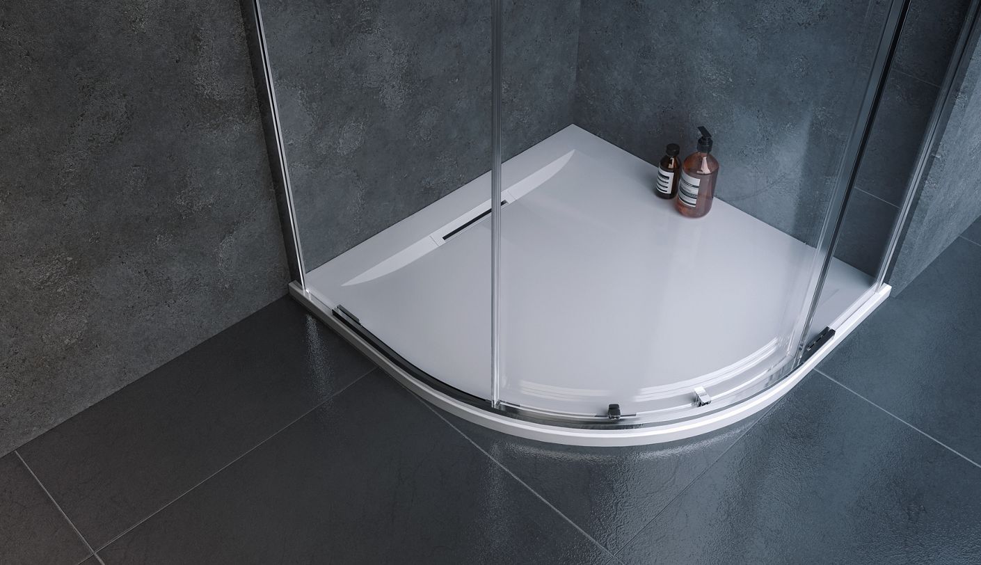 A quadrant shower tray in a grey bathroom with bottles of shower gel