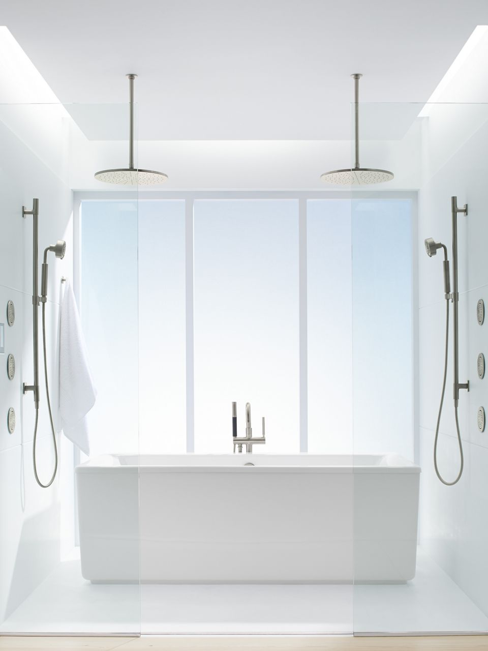 Closeup of bathing alcove featuring a Stargaze freestanding bath with Stillness handshowers and WaterTiles on either side with two, fourteen inch rain showerheads hanging from the ceiling.