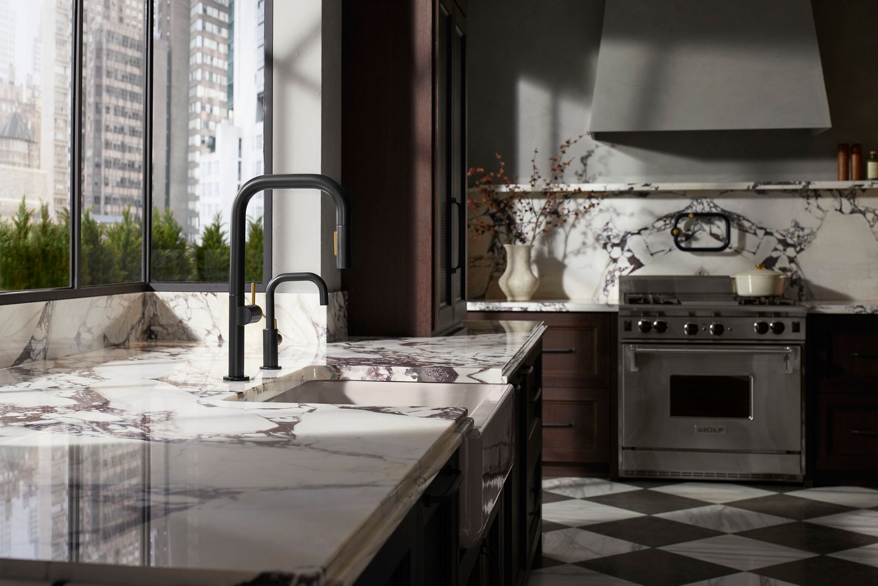 A Components collection kitchen faucet and beverage faucet on a marbled stone coutner top.