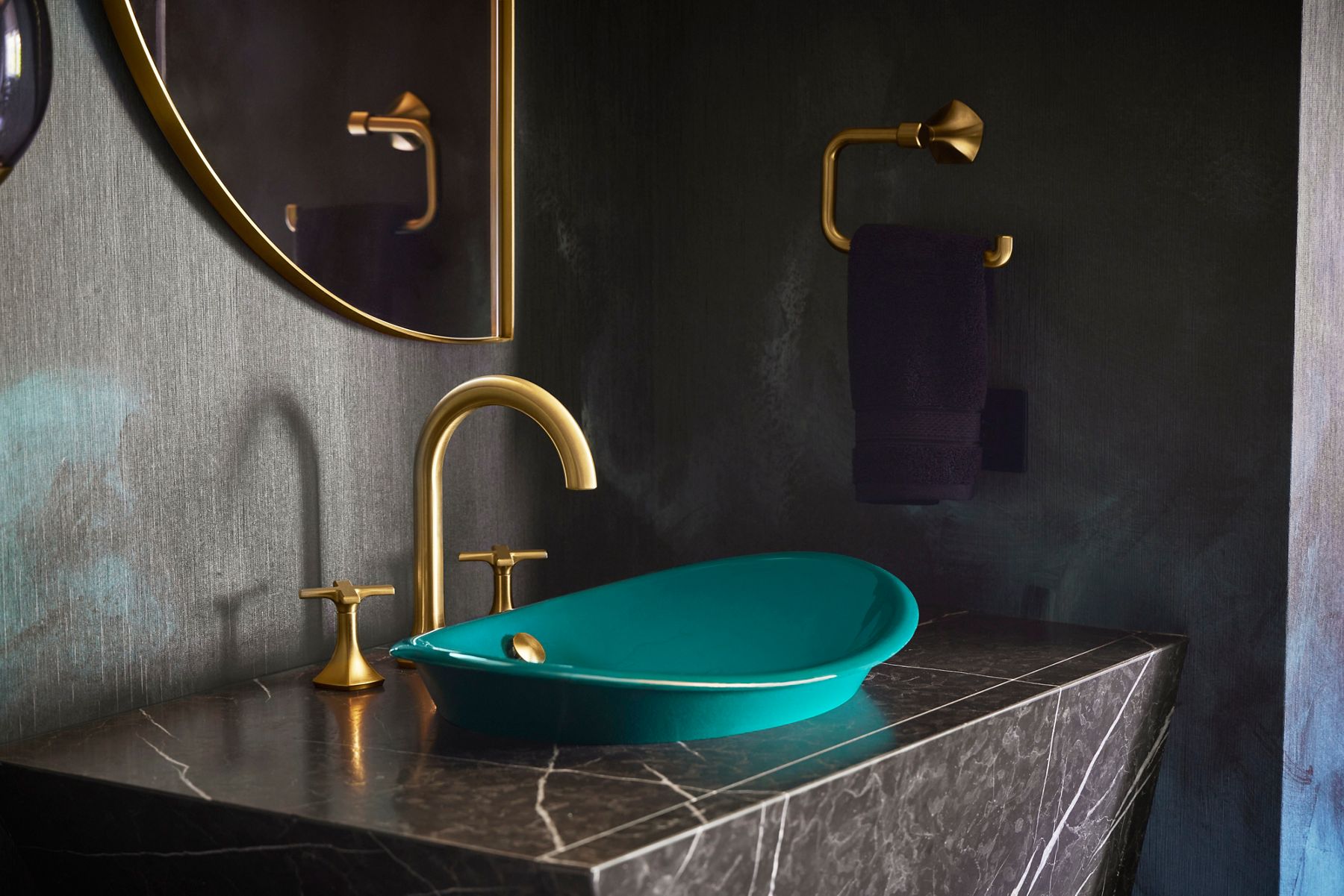 Vibrant blue ceramic sink with gold faucet on black marble vanity