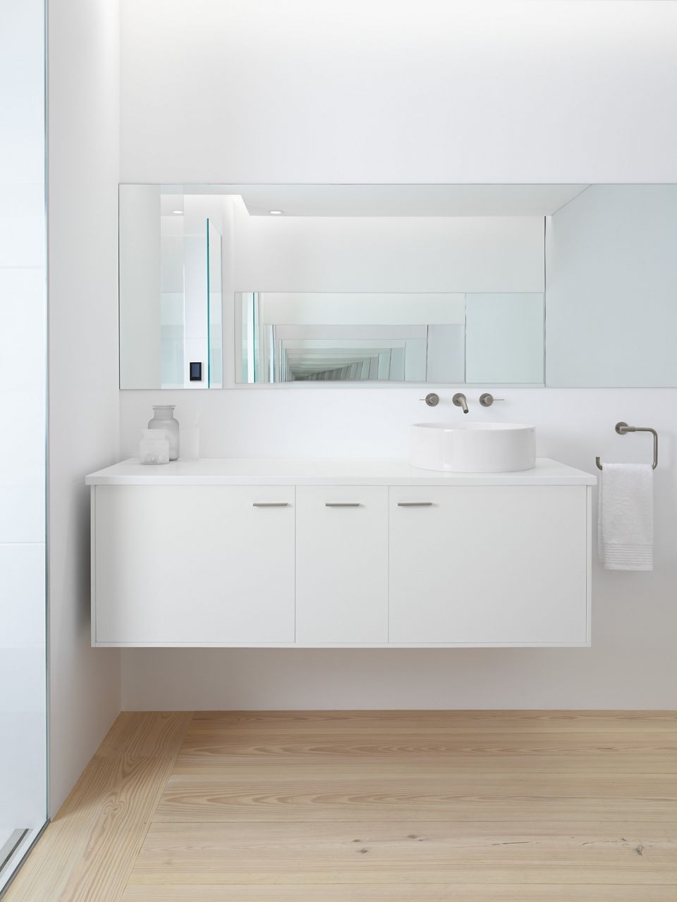 Closeup of bathing alcove featuring a Stargaze freestanding bath with Stillness handshowers and WaterTiles on either side with two, fourteen inch rain showerheads hanging from the ceiling. 