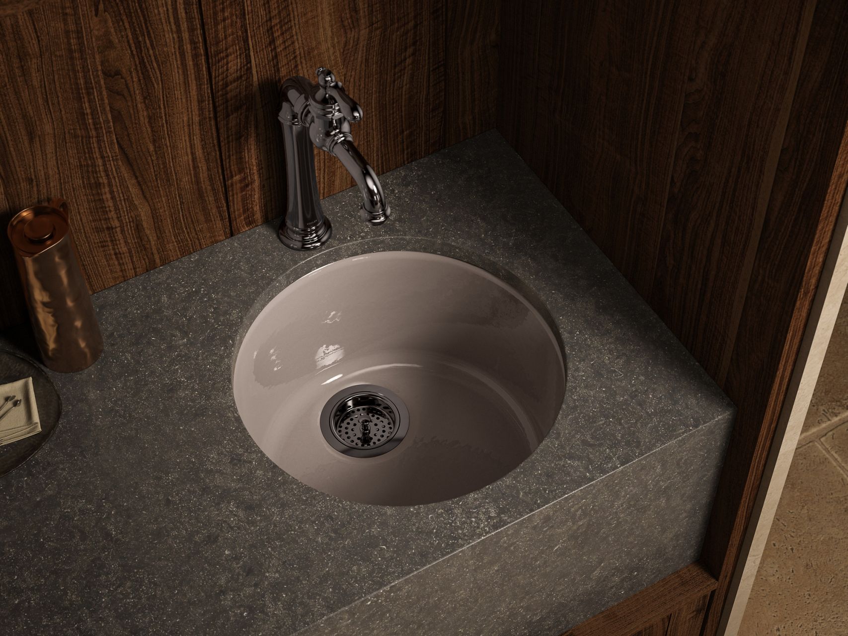 Round undermount sink in a granite countertop with a classic chrome faucet.