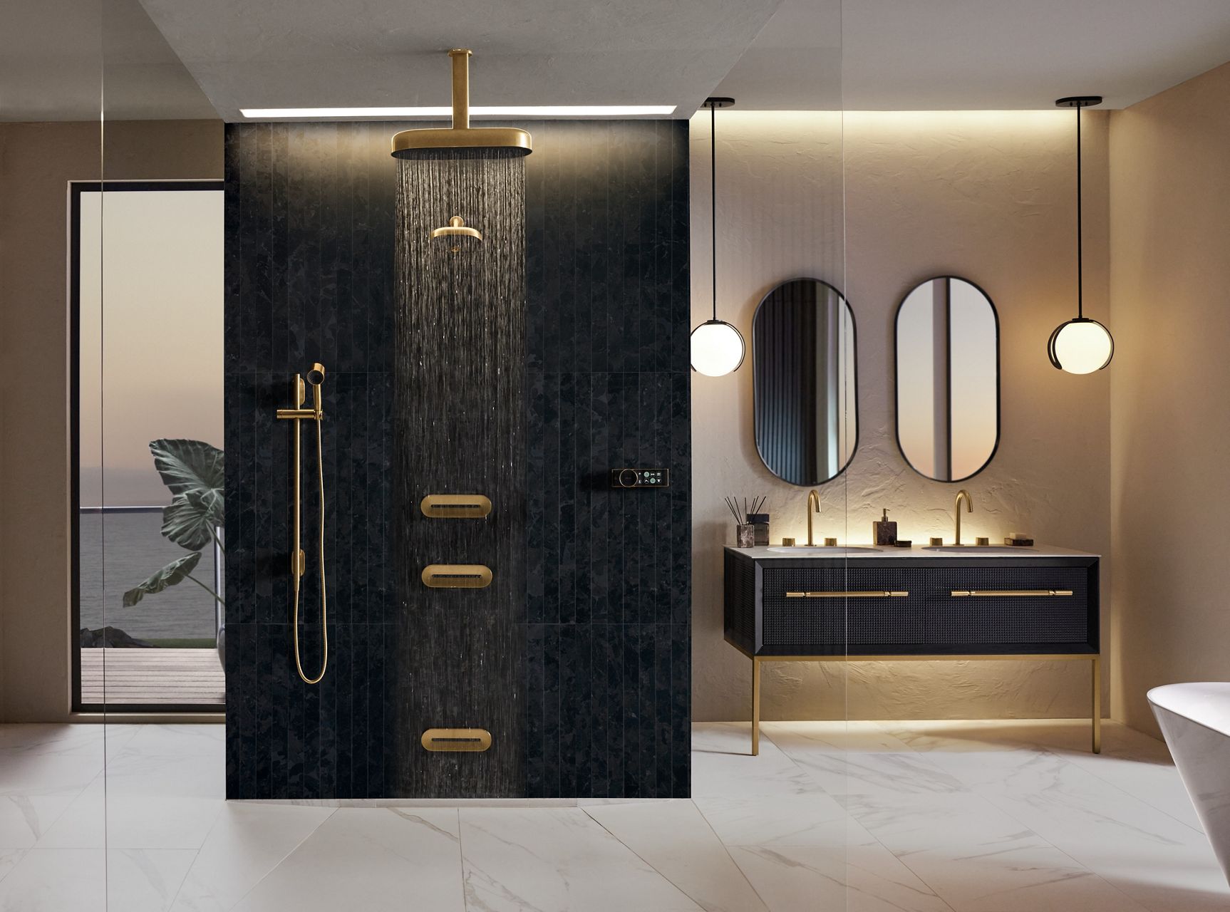A large bathroom in tones of black, tan, and gold with an open air shower in the center that includes a rainhead, showerhead, body sprays, and handshower.