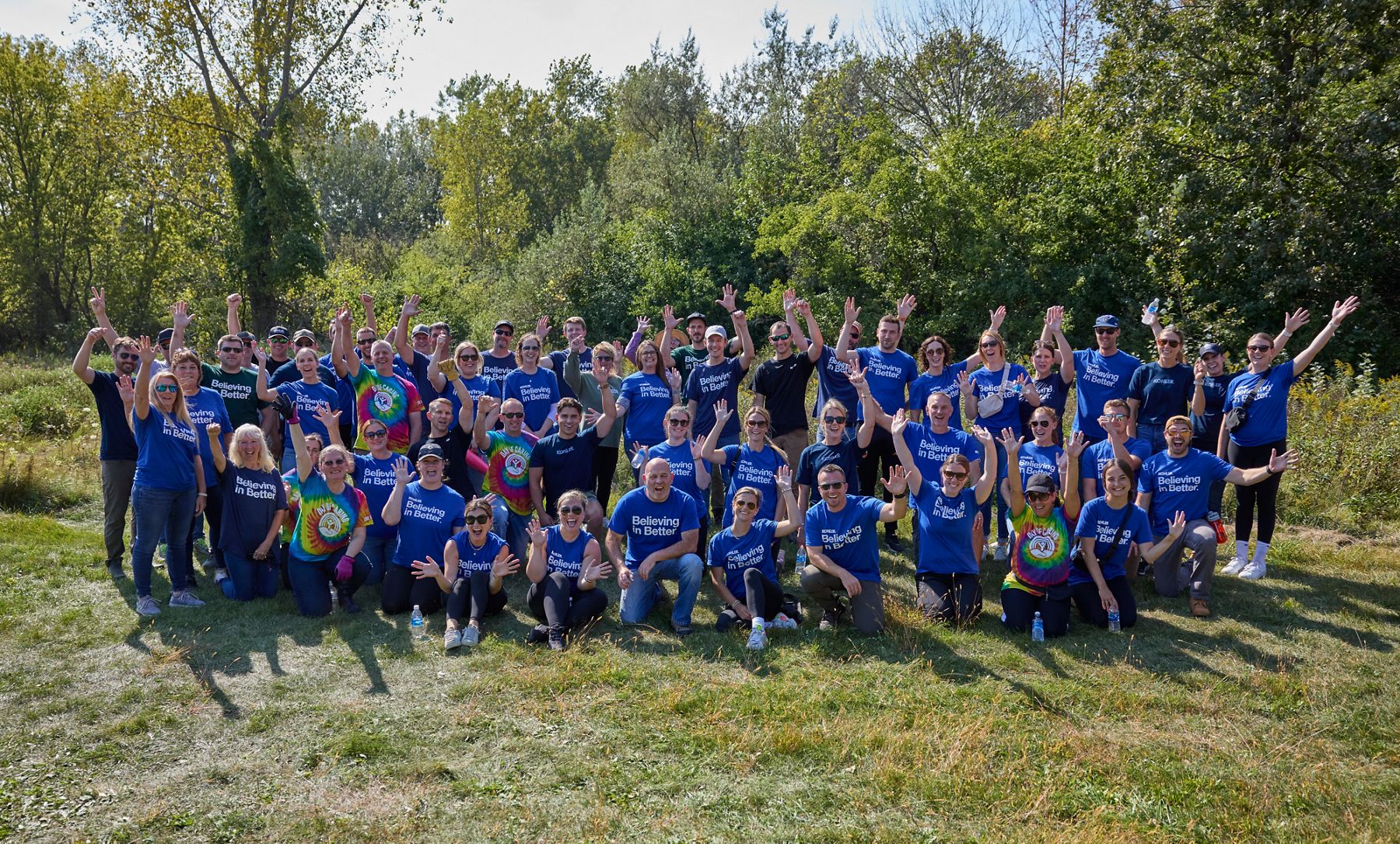 Kohler associates in “Believing in Better” shirts posing for a community volunteer event photo.