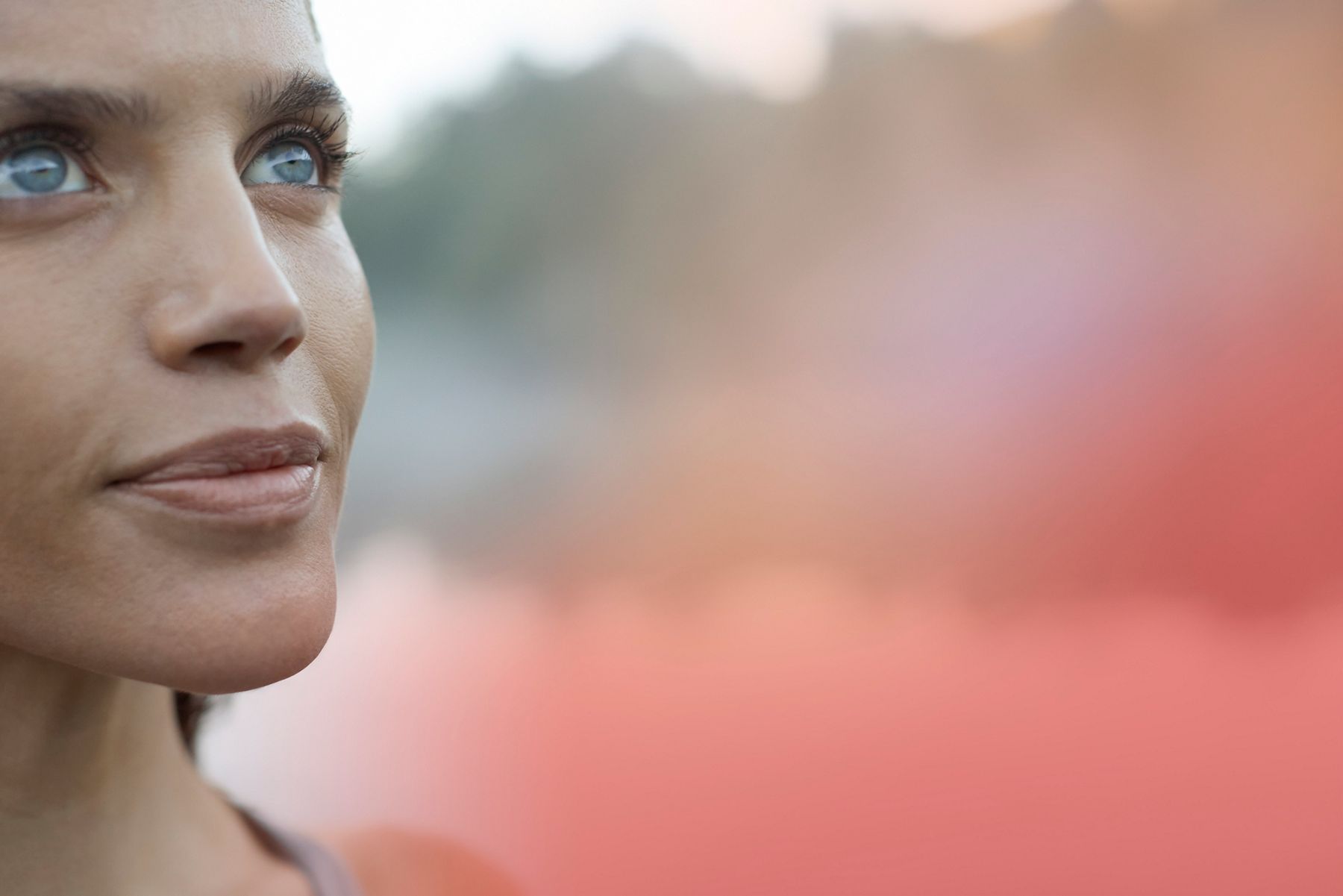 Close-up of a woman's face gazing thoughtfully into the distance.