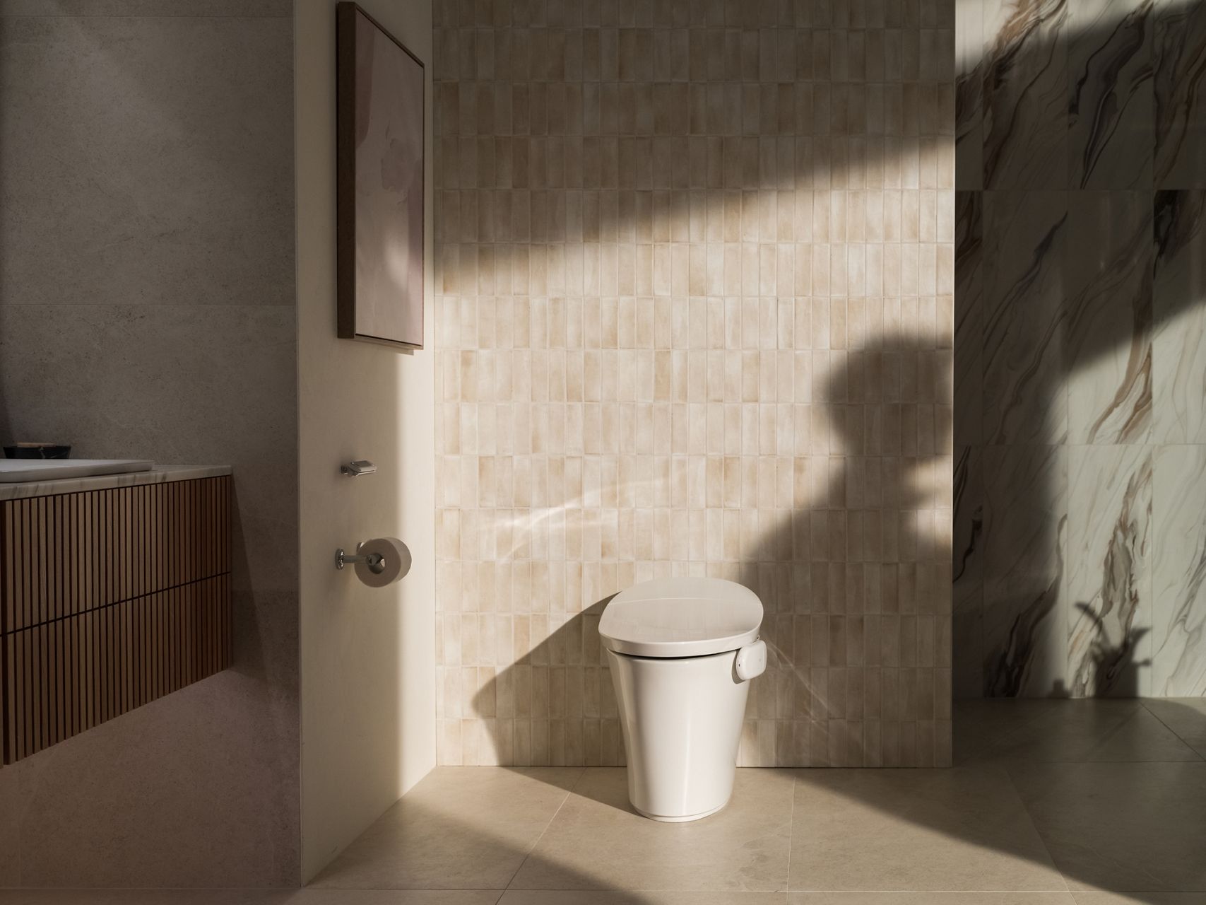 Front view of a toilet fitted with the Kohler Health Dekoda device in a bright, modern bathroom setting.