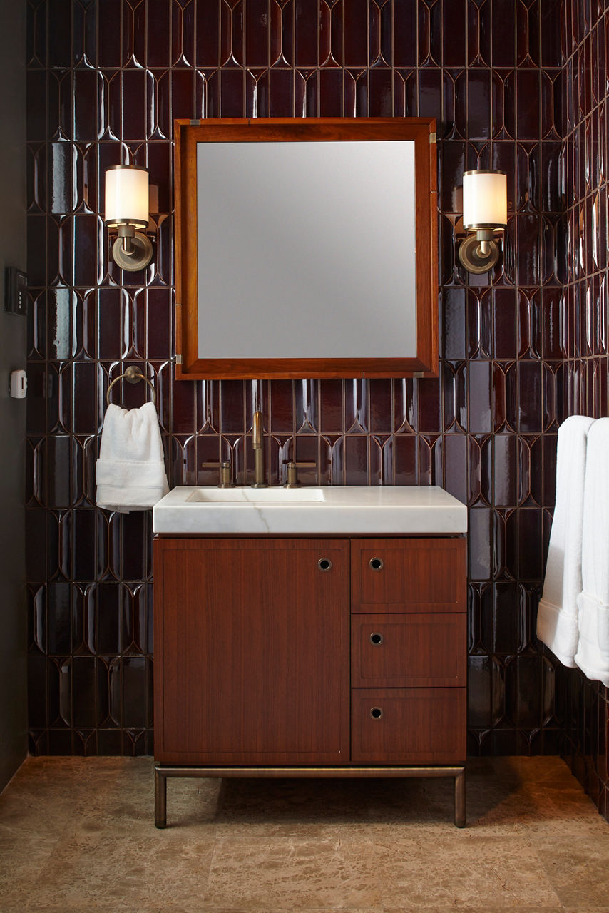 Ann Sacks Houston showroom interior view of vignette with wood vanity and burgundy geometric wall tile