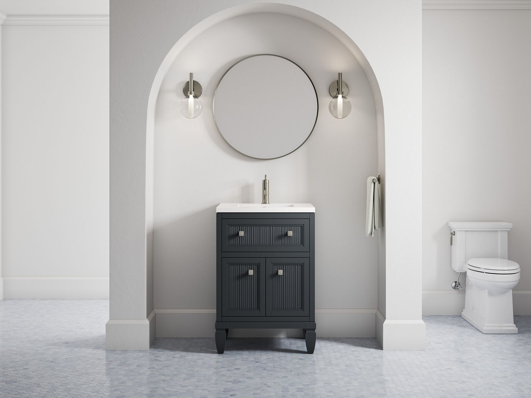 A 24-inch Hearthhaven vanity in slate grey along with a round mirror and two sconce lights in an off-white alcove with a rounded top.