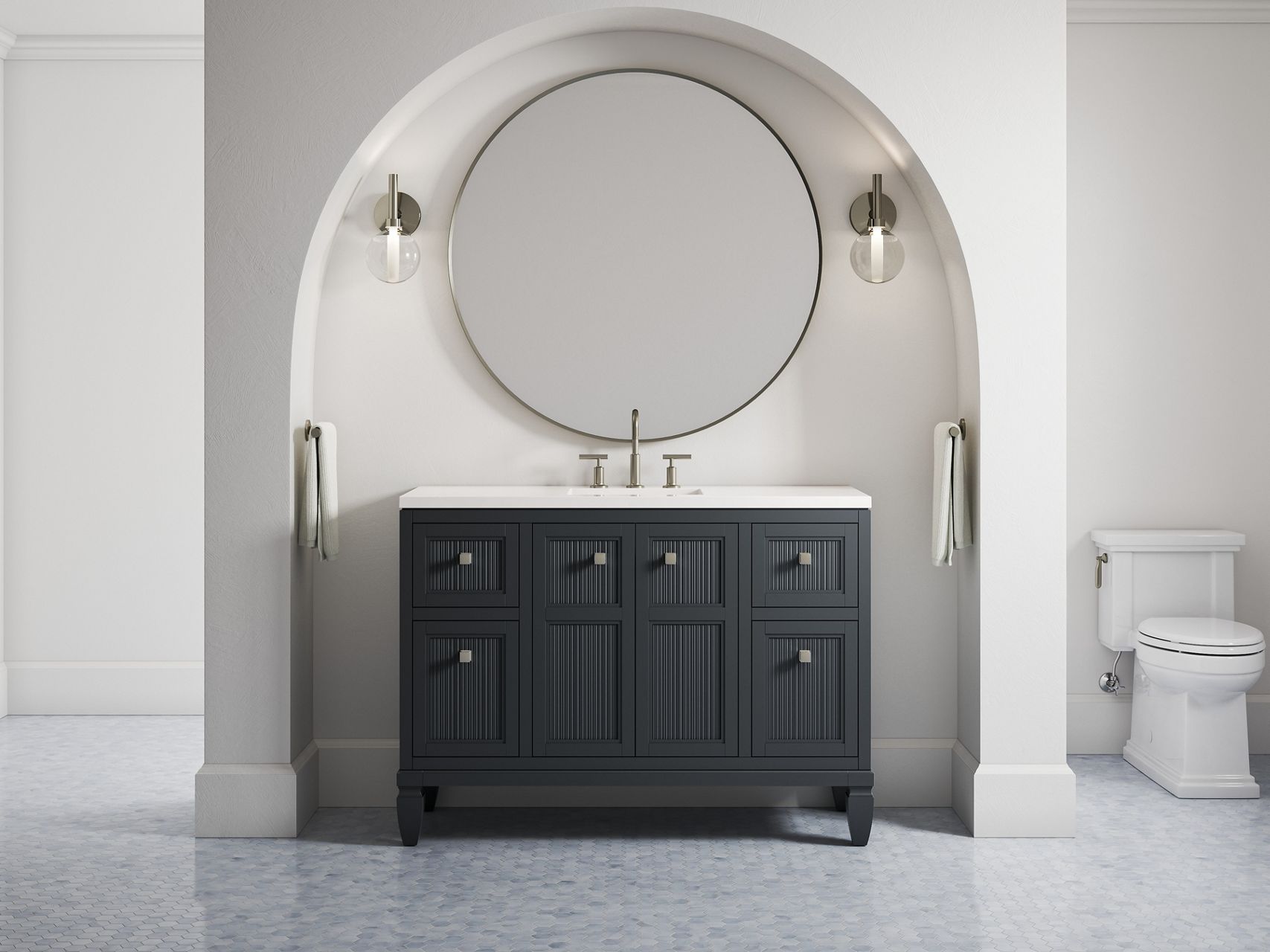 A 48-inch Hearthhaven vanity in slate grey along with a round mirror and two sconce lights in an off-white alcove with a rounded top.