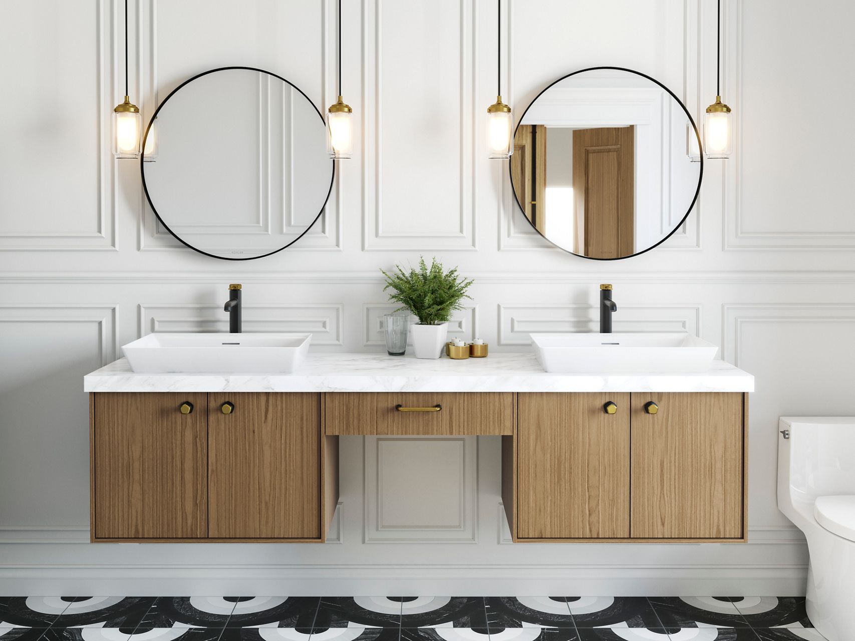 A light wood tone wall-mount vanity with a white vessel sink, two-tone faucet, white wall with framing, a circle mirror and pendant lights.