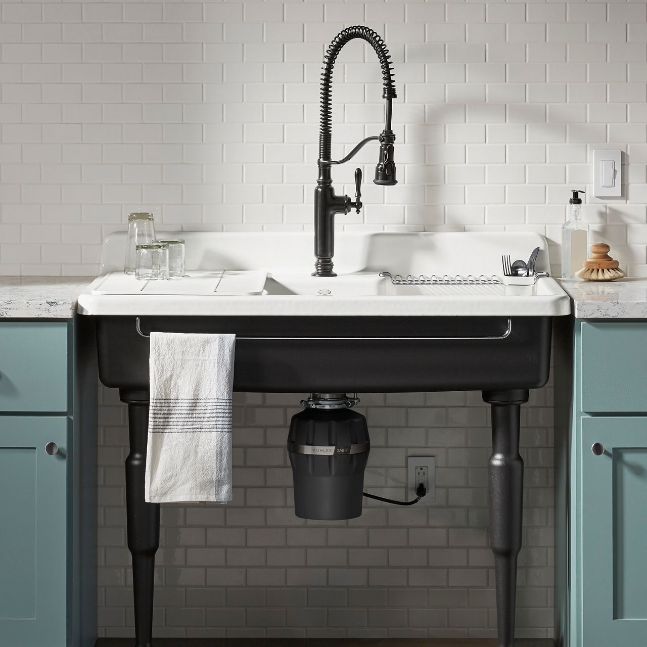 A cast iron console kitchen sink with a garbage disposal below it.