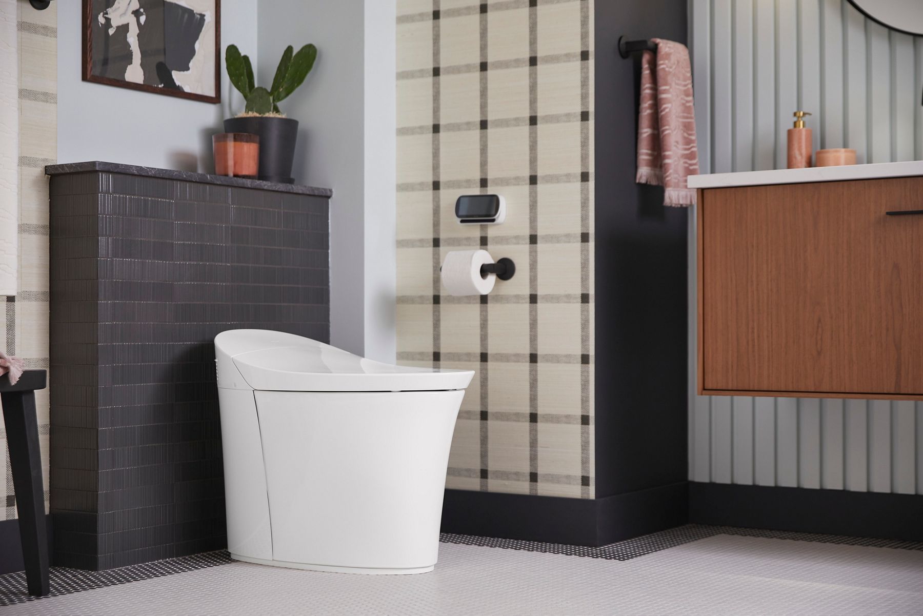 A tankless smart toilet in a bathroom with gray tiles, checkered wall paper, striped wall paper, and a floating wood grain vanity.