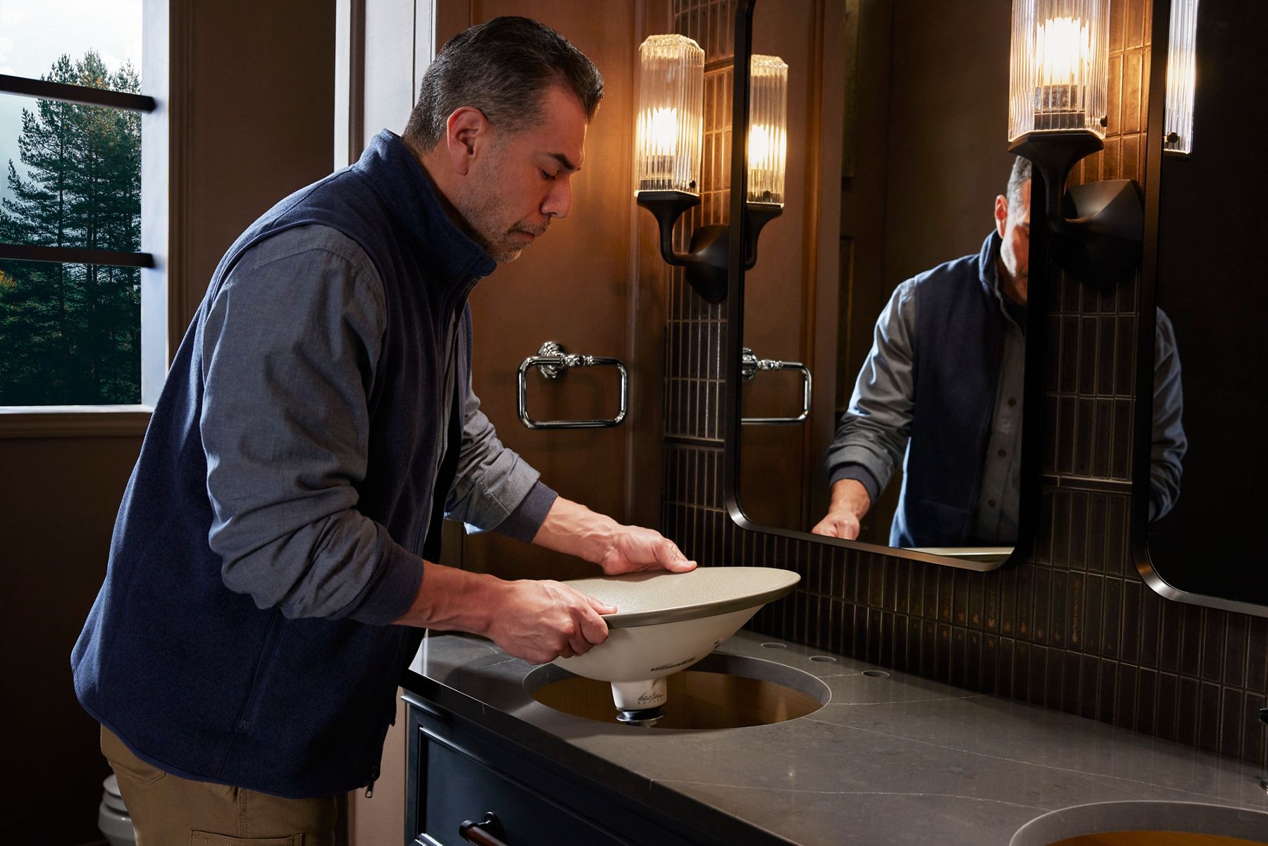 Installer placing a bathroom sink into a countertop.
