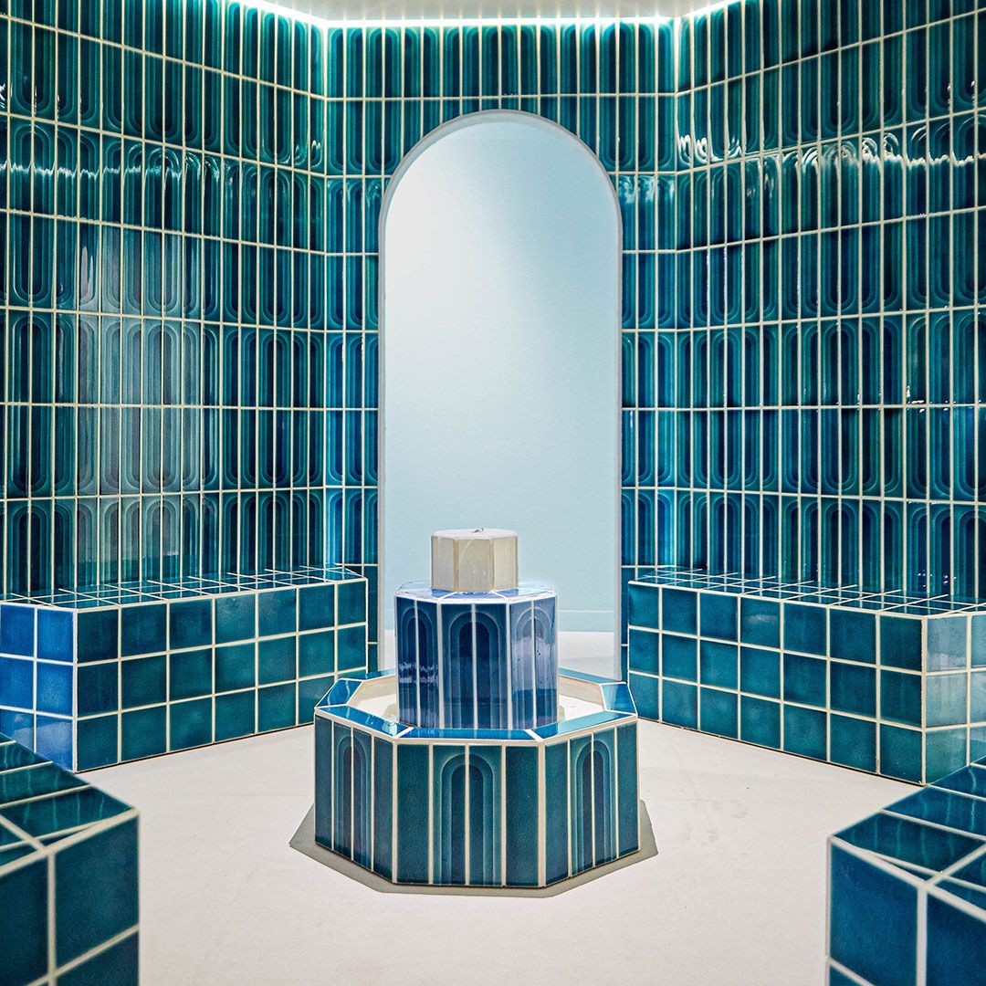 A room with the arch pattern tile in varying shades of blue on the walls from ceiling to floor.