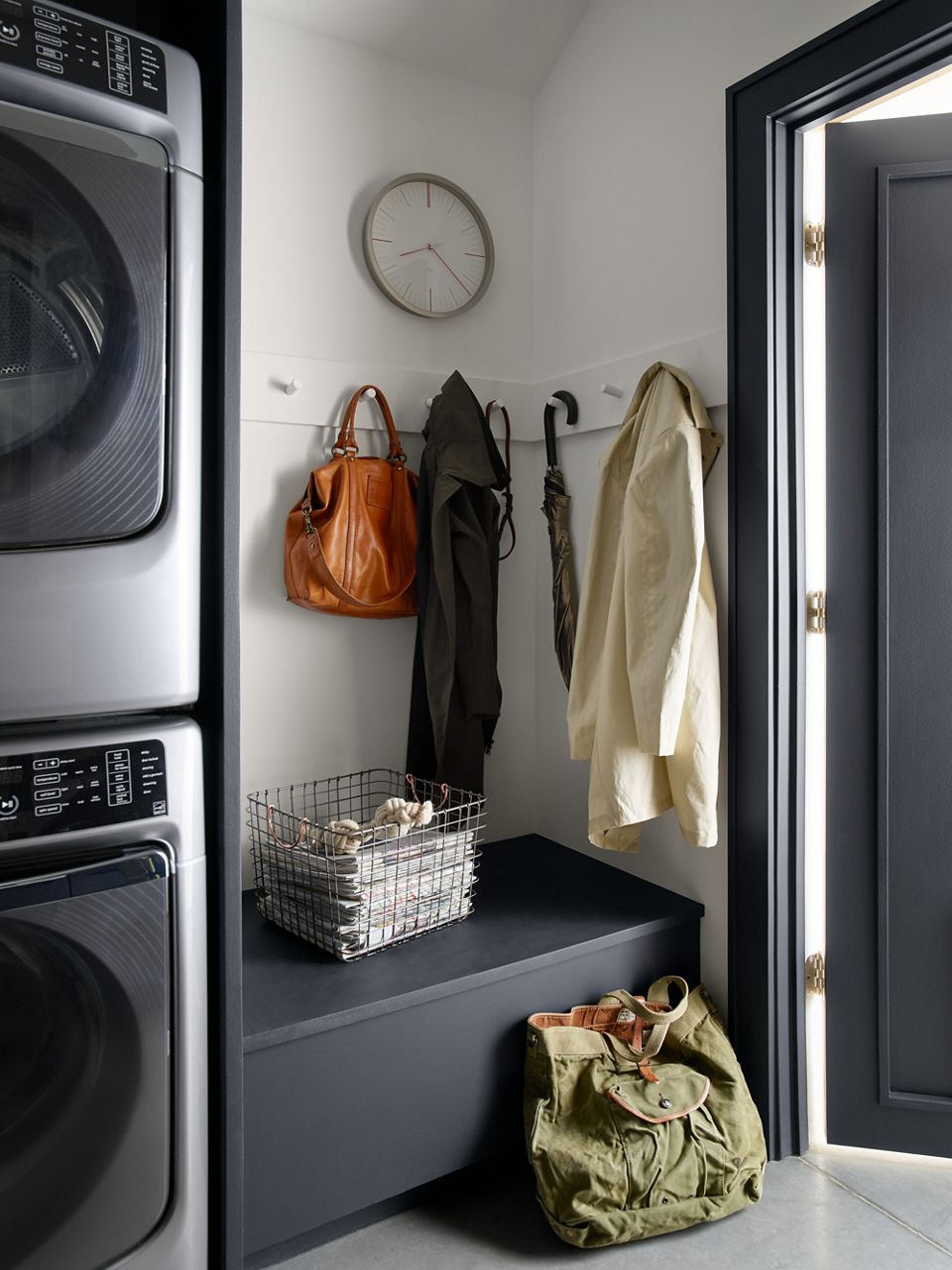 Utility room corner with coats on coat hooks and storage bench