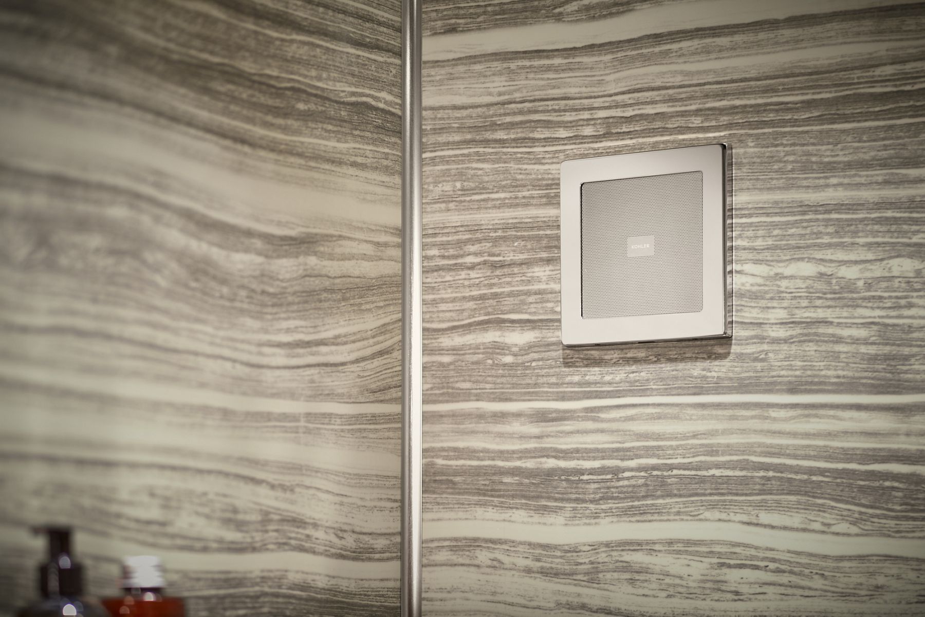 A KOHLER digital shower control panel on a tile shower wall.