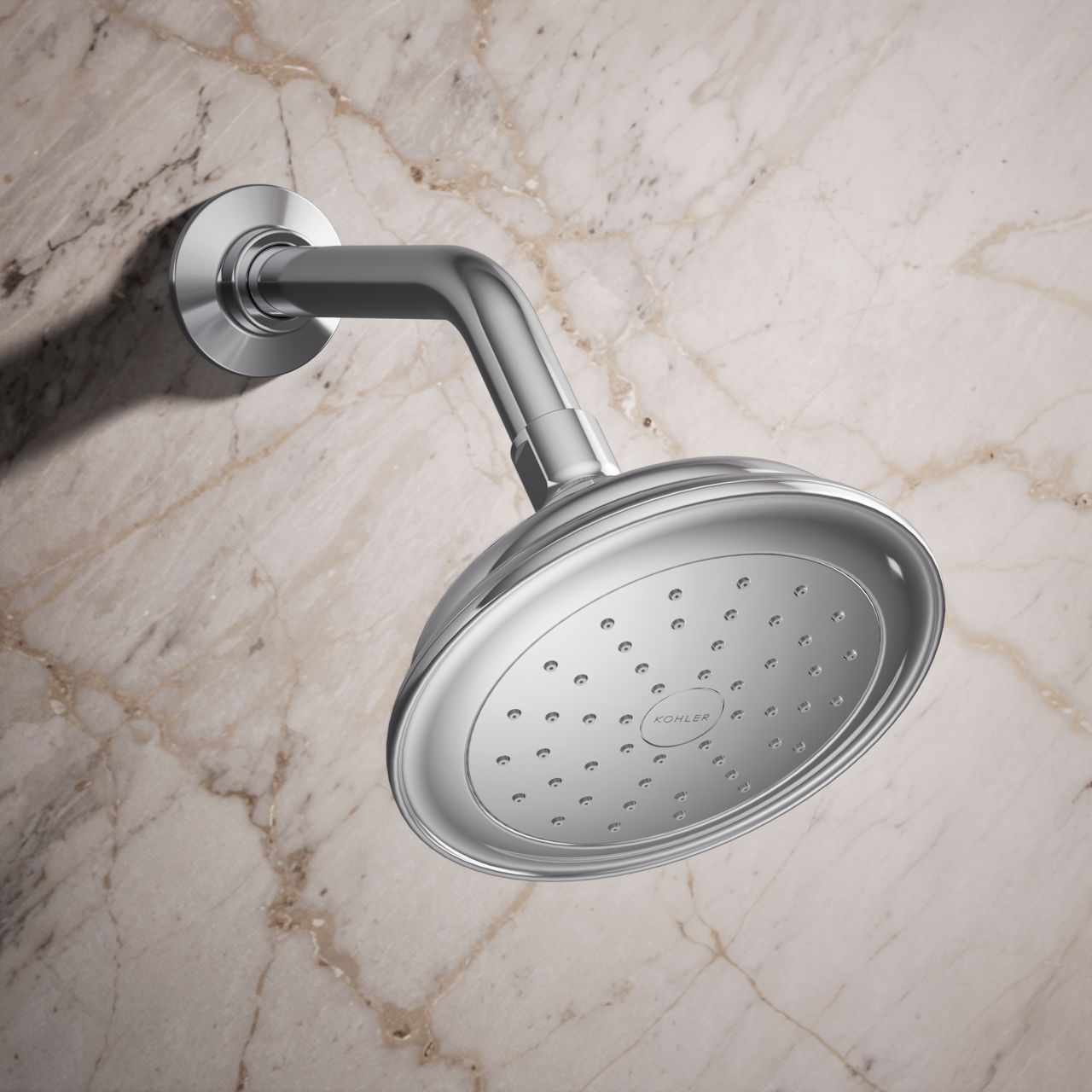 Traditional-style round chrome shower head mounted on a shower arm against a marble tile wall.