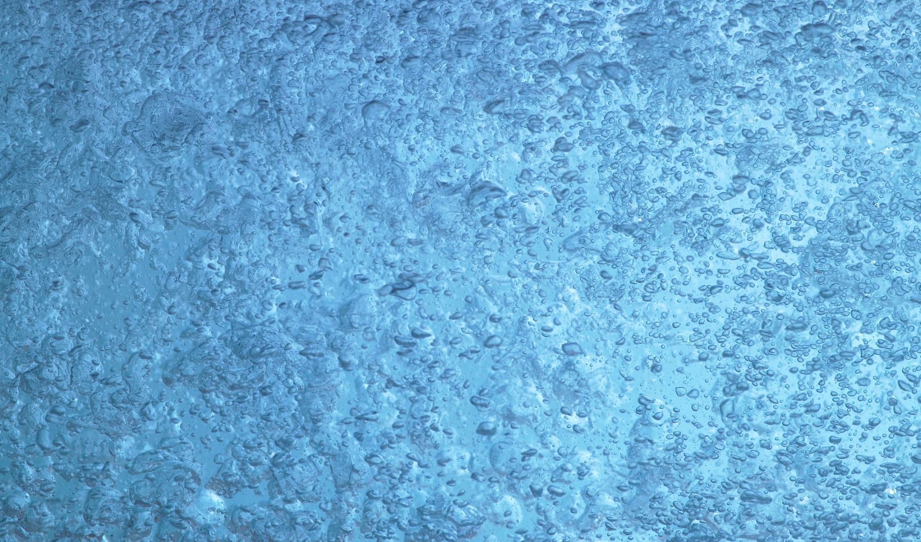 Blue water inundated with air bubbles from a KOHLER bath with BubbleMassage hydrotherapy.