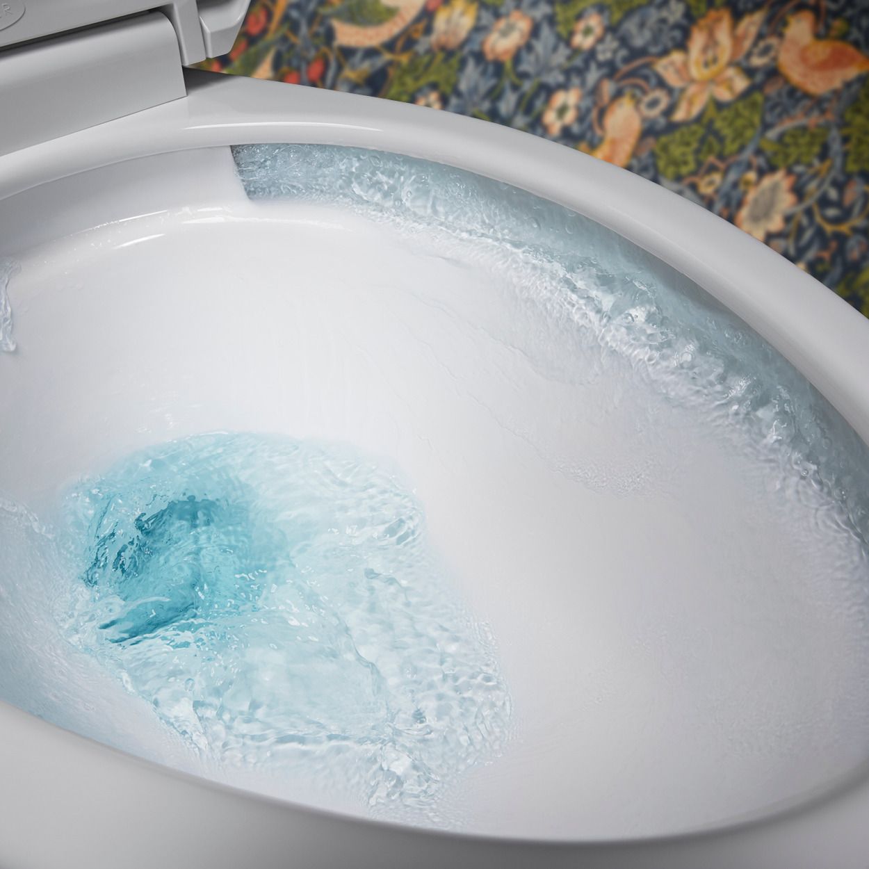 A close-up image of water swirling around the inside of a toilet bowl, demonstrating the Revolution 360 flush technology.