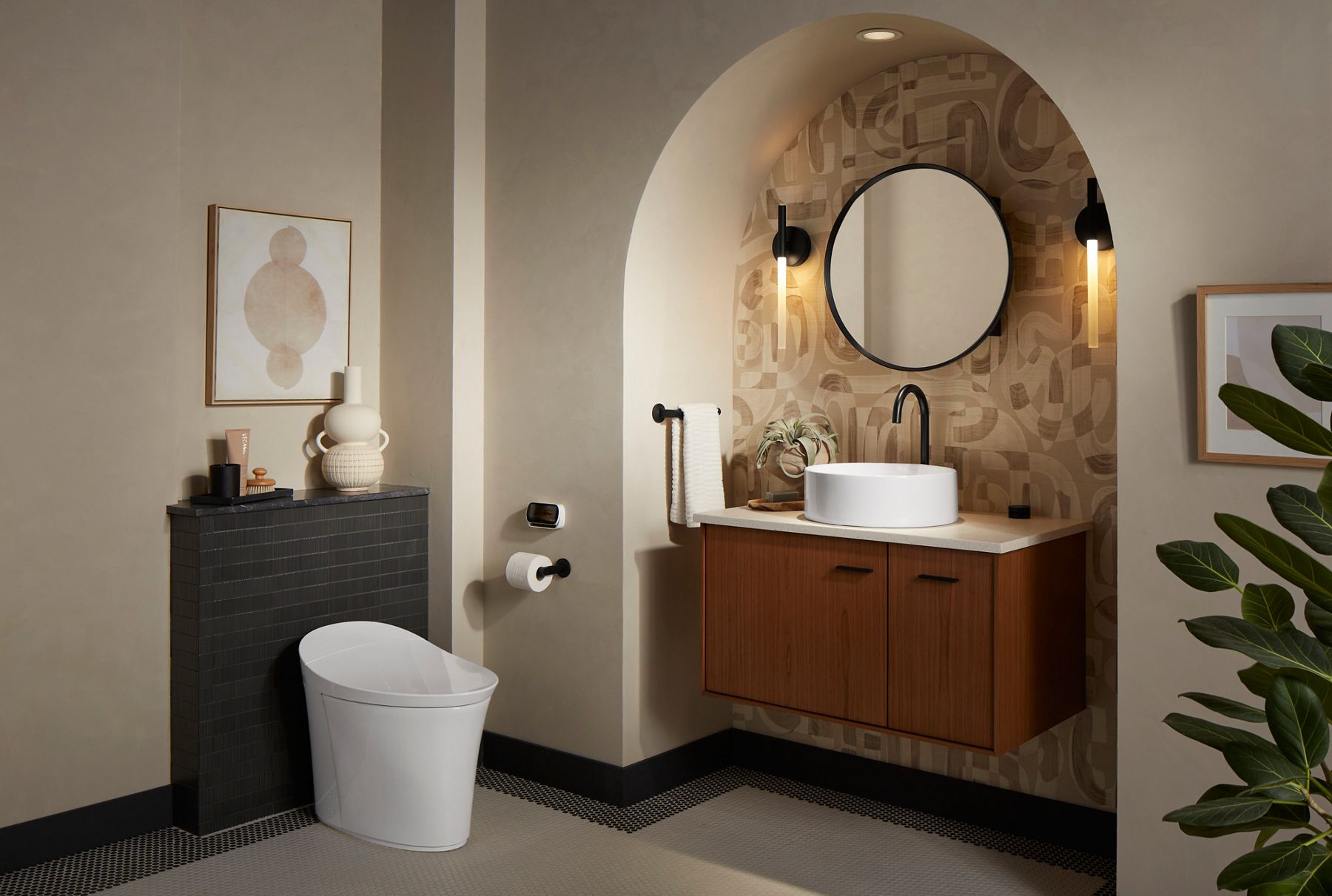 Modern vanity with circular mirror and adjacent white toilet.