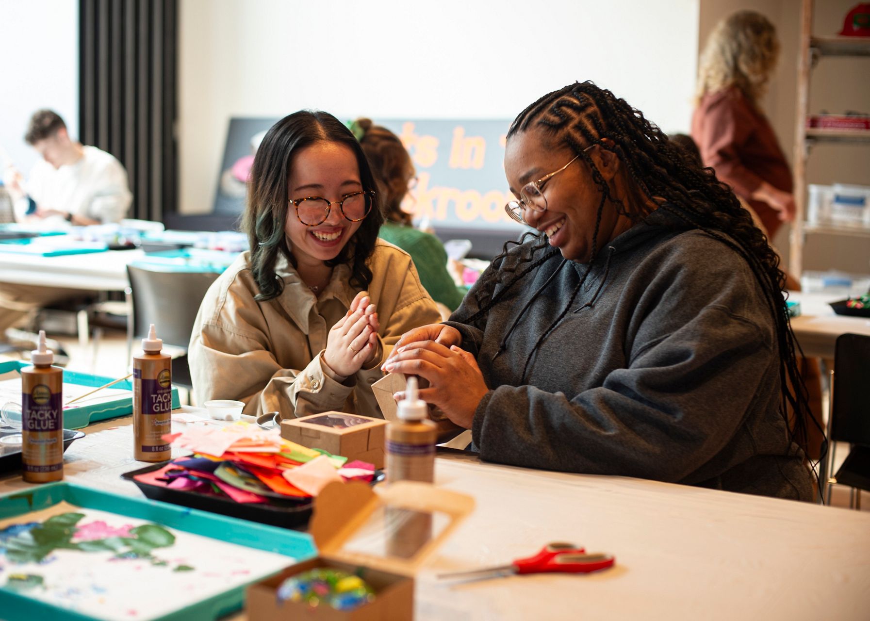 Smiling women working together on a creative project during a Kohler Stewardship Giving initiative.