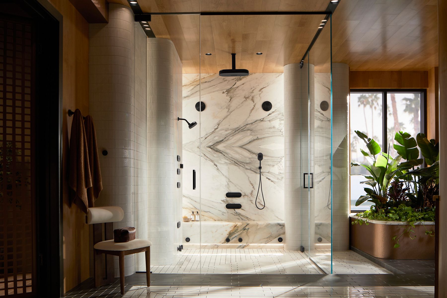 Modern digital showering system with black finishes in a large marble shower.