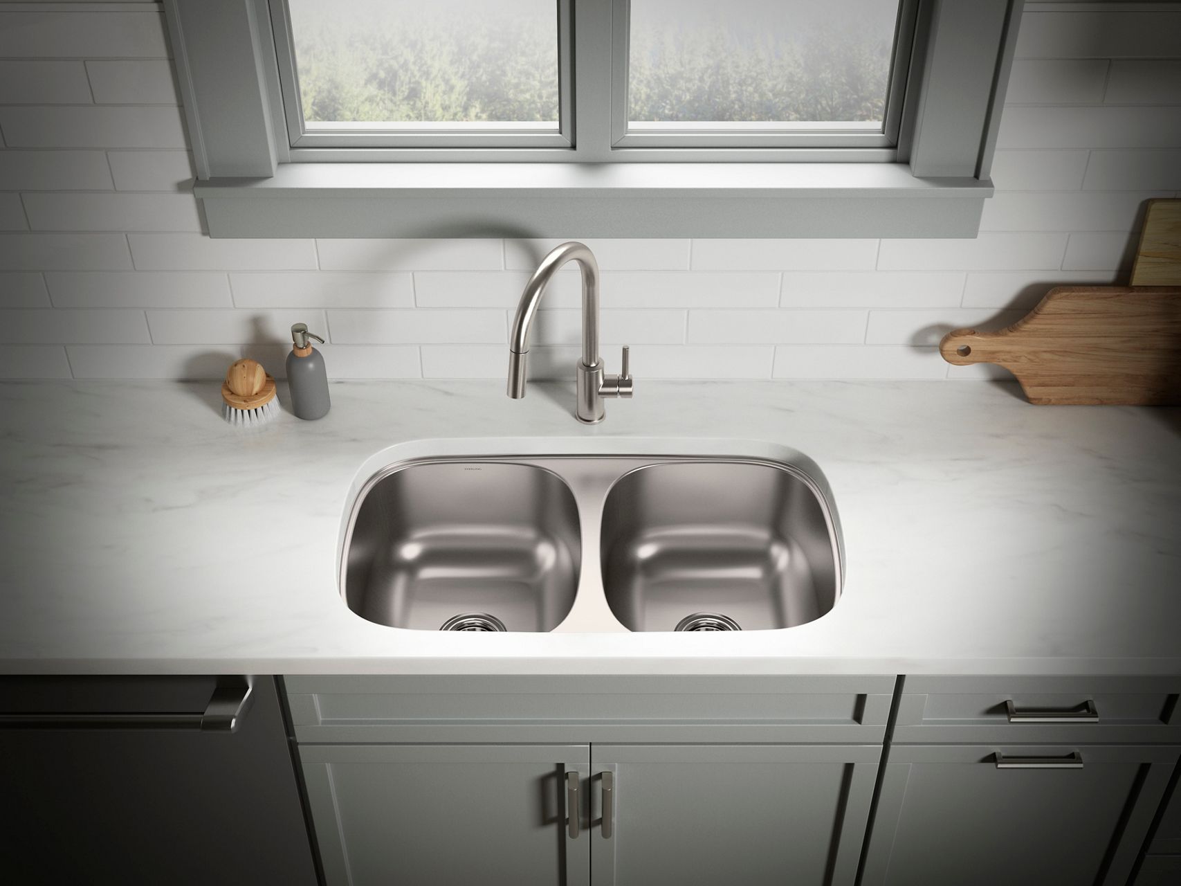 Double undermount stainless steel sink and faucet in a bright white and gray kitchen.