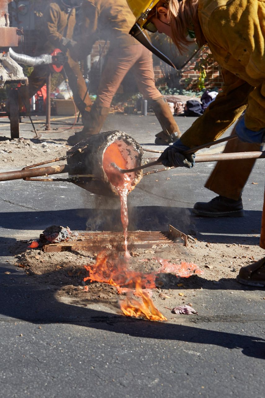Alumni Weekend event with artists pouring molten metal during a live demonstration.