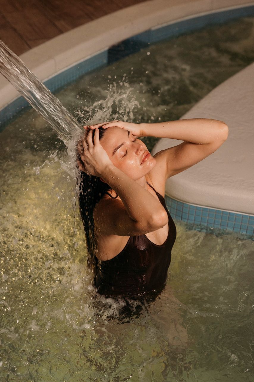 Woman rinsing hair in a pool.
