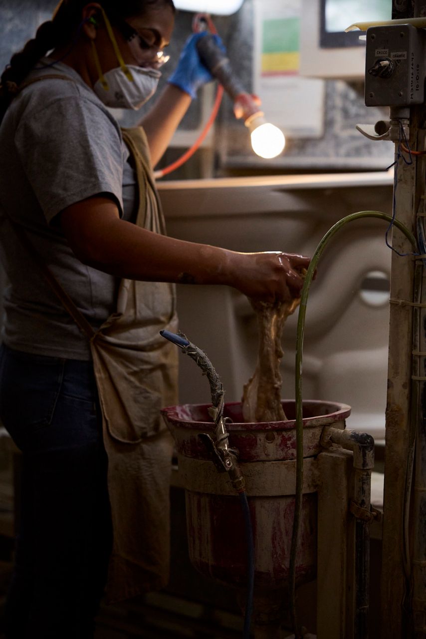 Industrial worker using machinery in a manufacturing facility.