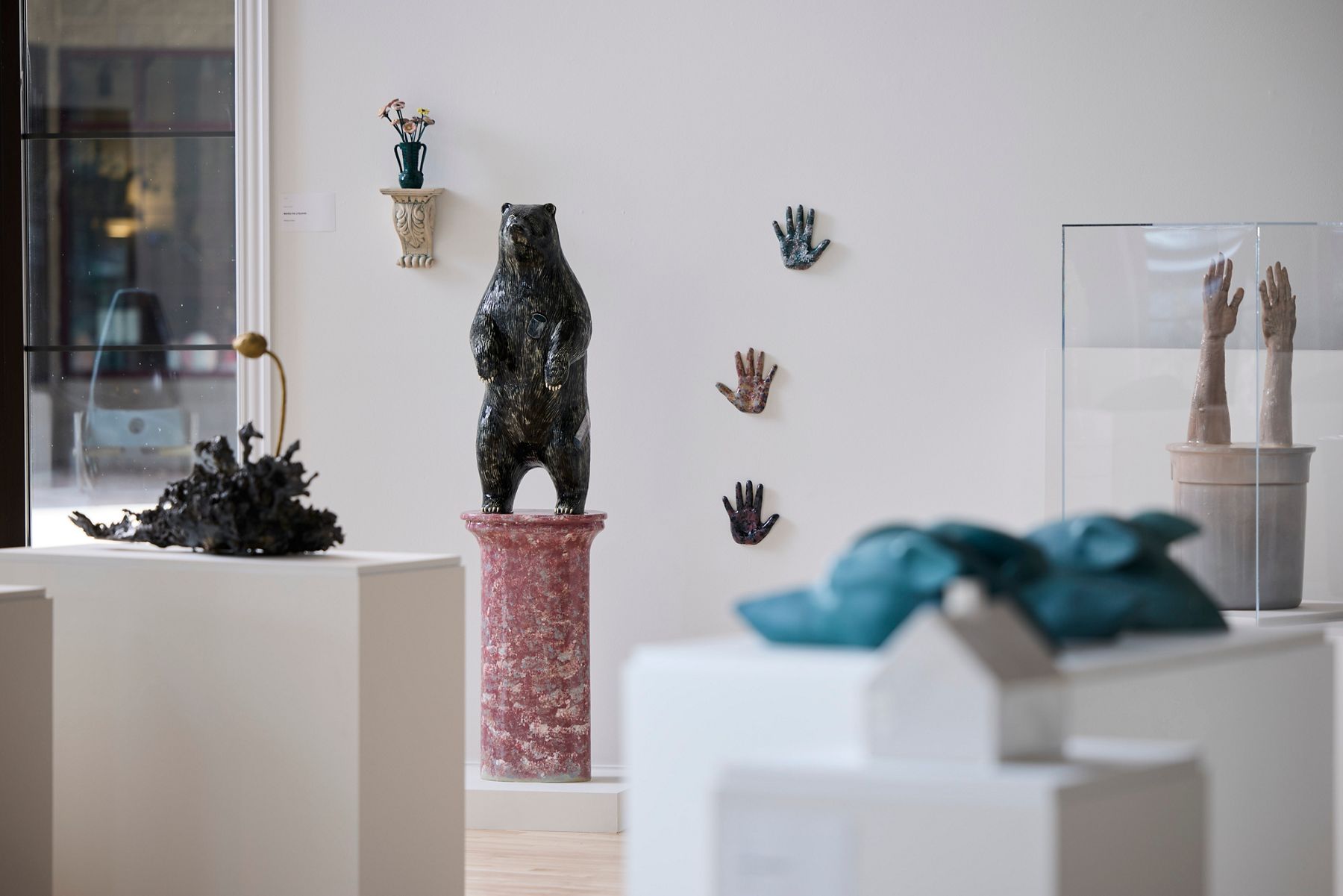 A/I 50th Collective exhibition featuring a black bear sculpture and mixed-media artwork.