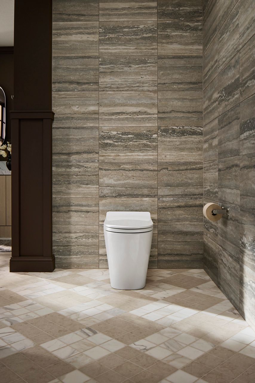 White smart toilet in a sunny bathroom with gray stone walls, cream tiled flooring, and dark wood accents.