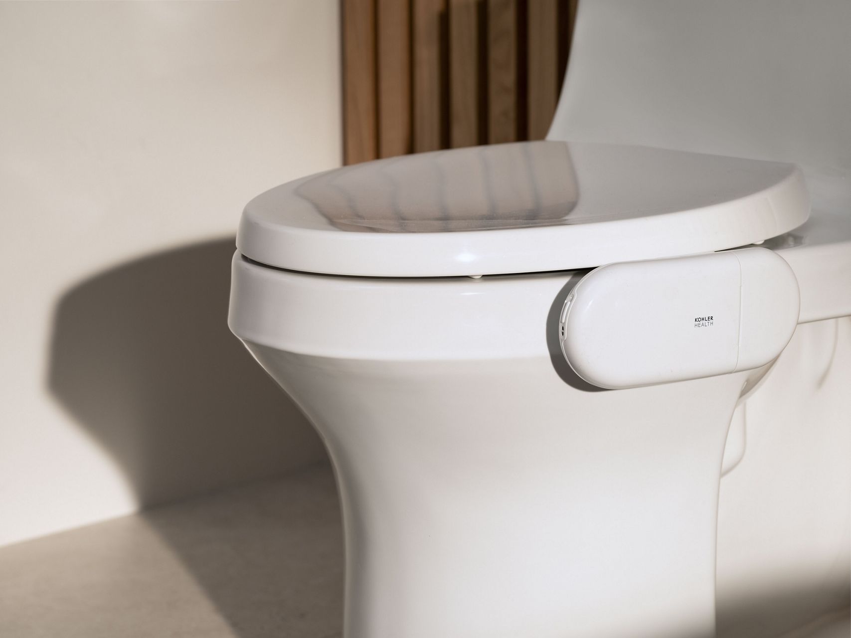 Health tracking device attached to the side of a white KOHLER Toilet.